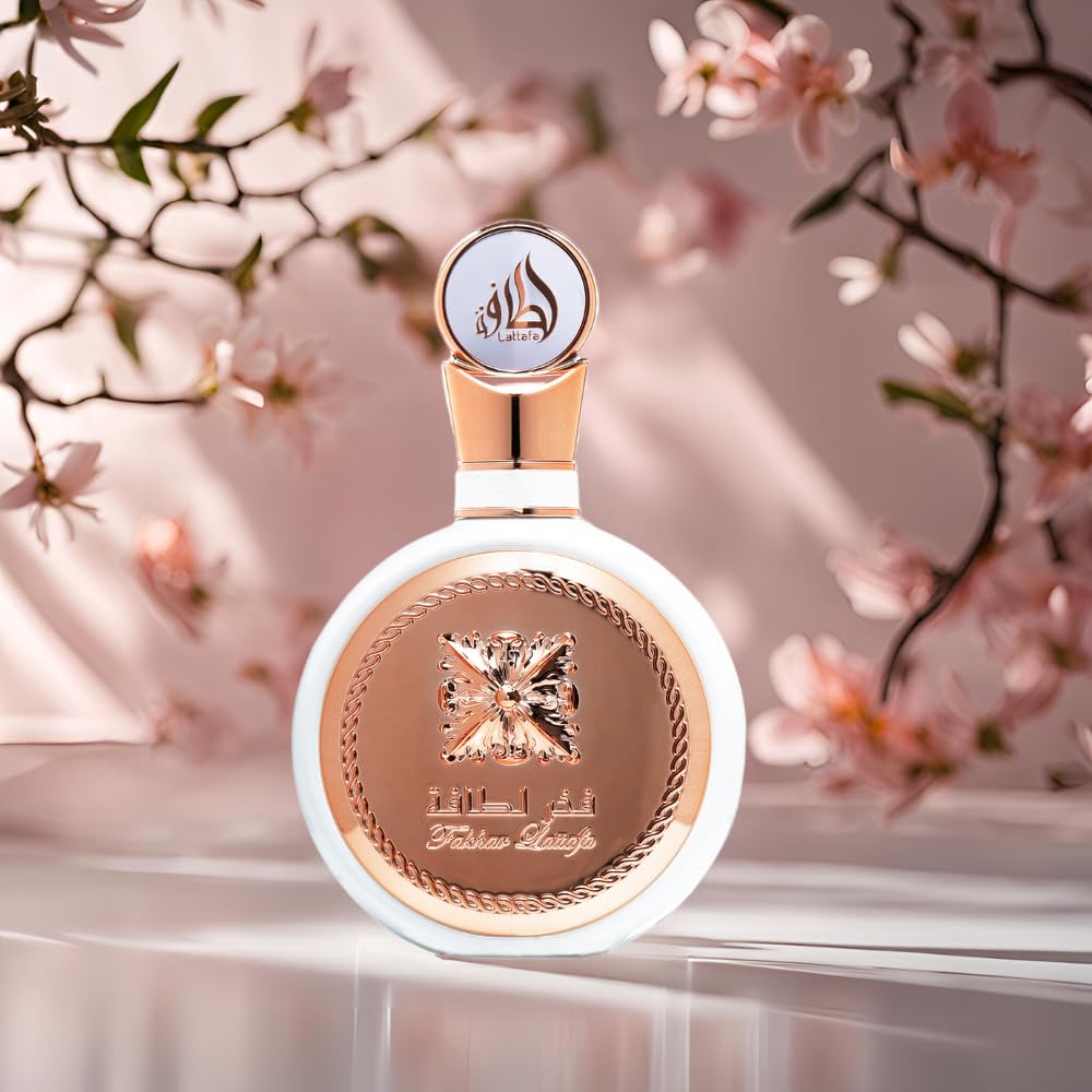 Lattafa Fakhar Women perfume bottle with elegant rose gold and white design surrounded by pink flowers