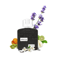Black perfume bottle with silver square cap, shown with floral and citrus accents