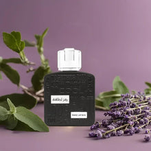 Black perfume bottle with silver square cap, with lavender and green leaves