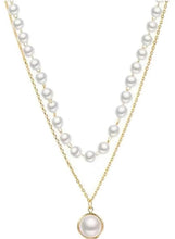Layered pearl pendant necklace with gold-tone chain, white pearls, and round pearl pendant