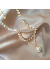 Huitich layered pearl pendant necklace with gold chains and white pearls on silky fabric