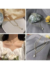 Layered pearl pendant necklace with gold-tone chain, white pearls, and teardrop pearl pendant