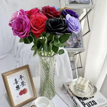 Artificial multi-color roses in a clear vase with green leaves