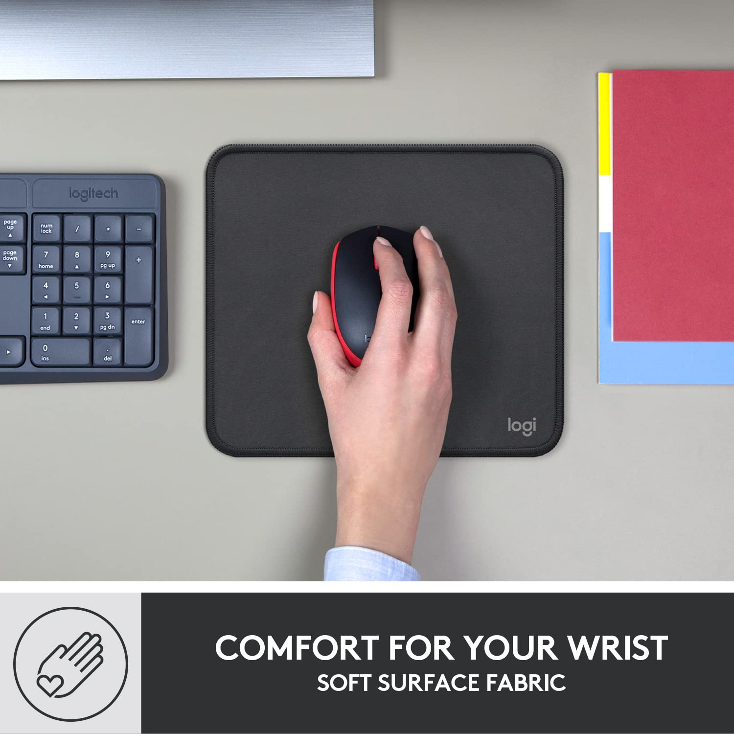 Logitech anti-slip computer mouse mat with soft surface fabric and wrist comfort holding a black and red mouse