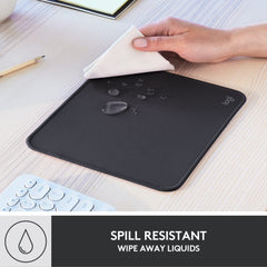 Logitech black anti-slip computer mouse mat with spill resistant surface being wiped clean