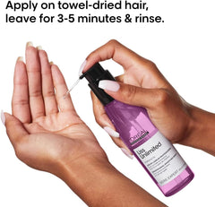 L'Oréal hair serum for frizzy hair in a hand, demonstrating application on towel-dried hair.
