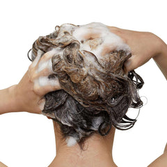 Applying L'Oréal Liss Unlimited anti-frizz shampoo to hair for smooth, frizz-free results