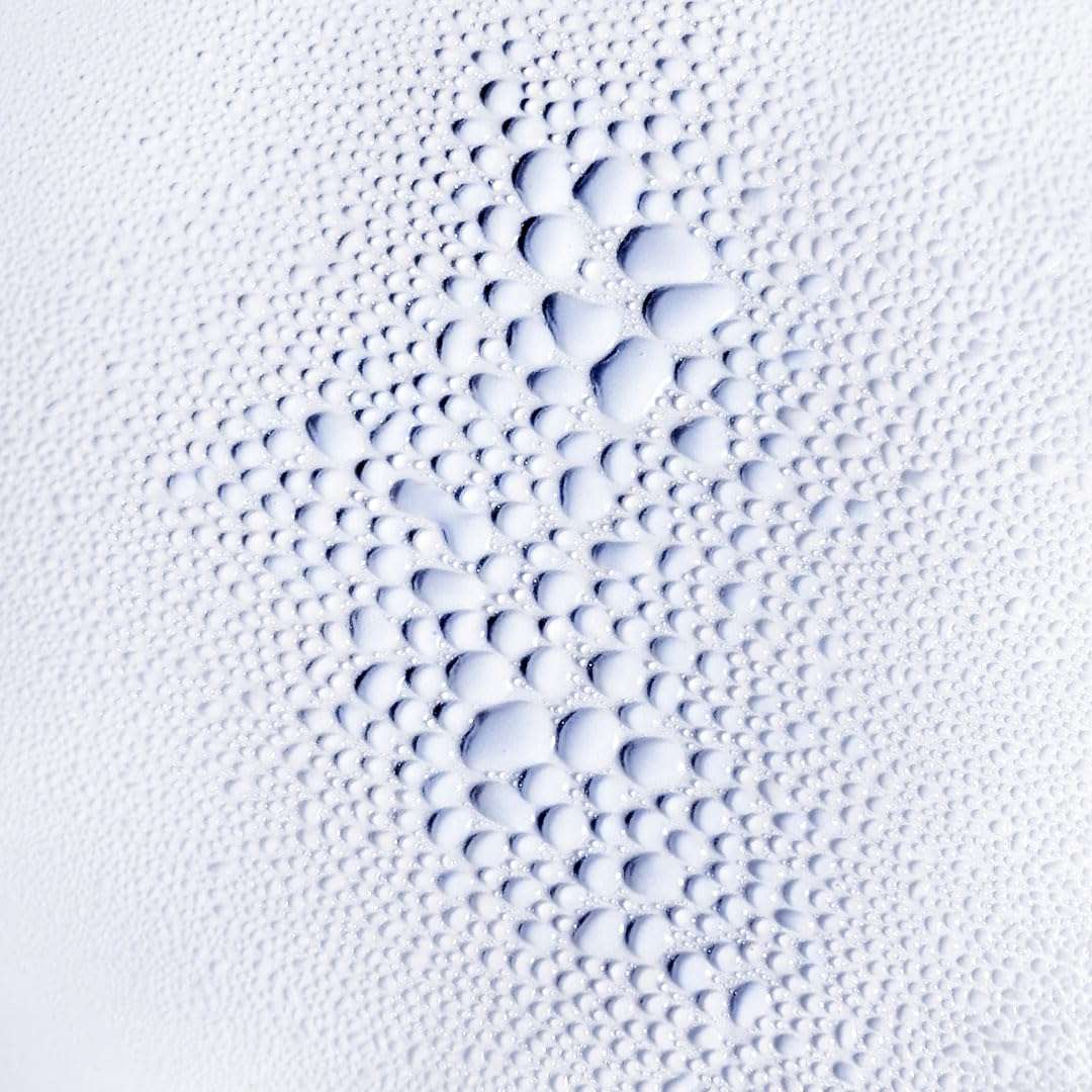 L’Oréal Serioxyl Advanced Serum for hair growth on a textured surface with fine bubbles