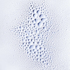 L’Oréal Serioxyl Advanced Serum for hair growth on a textured surface with fine bubbles