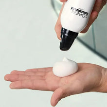 Hand dispensing white foam from L'Oréal Professionnel Volume Extra Full spray