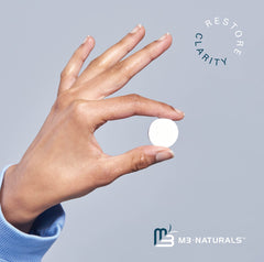 M3 Naturals retainer cleaner tablets shown as a single white effervescent tablet held between fingers