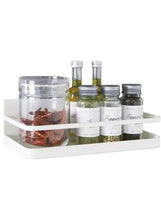 White metal magnetic rack holding spice jars and bottles