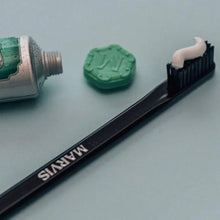 Black toothbrush with medium nylon bristles and MARVIS label on handle