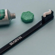 Slanted black toothbrush with medium bristles and MARVIS lettering