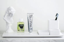 Marvis strong mint mouthwash concentrate bottle and tube on a white tray