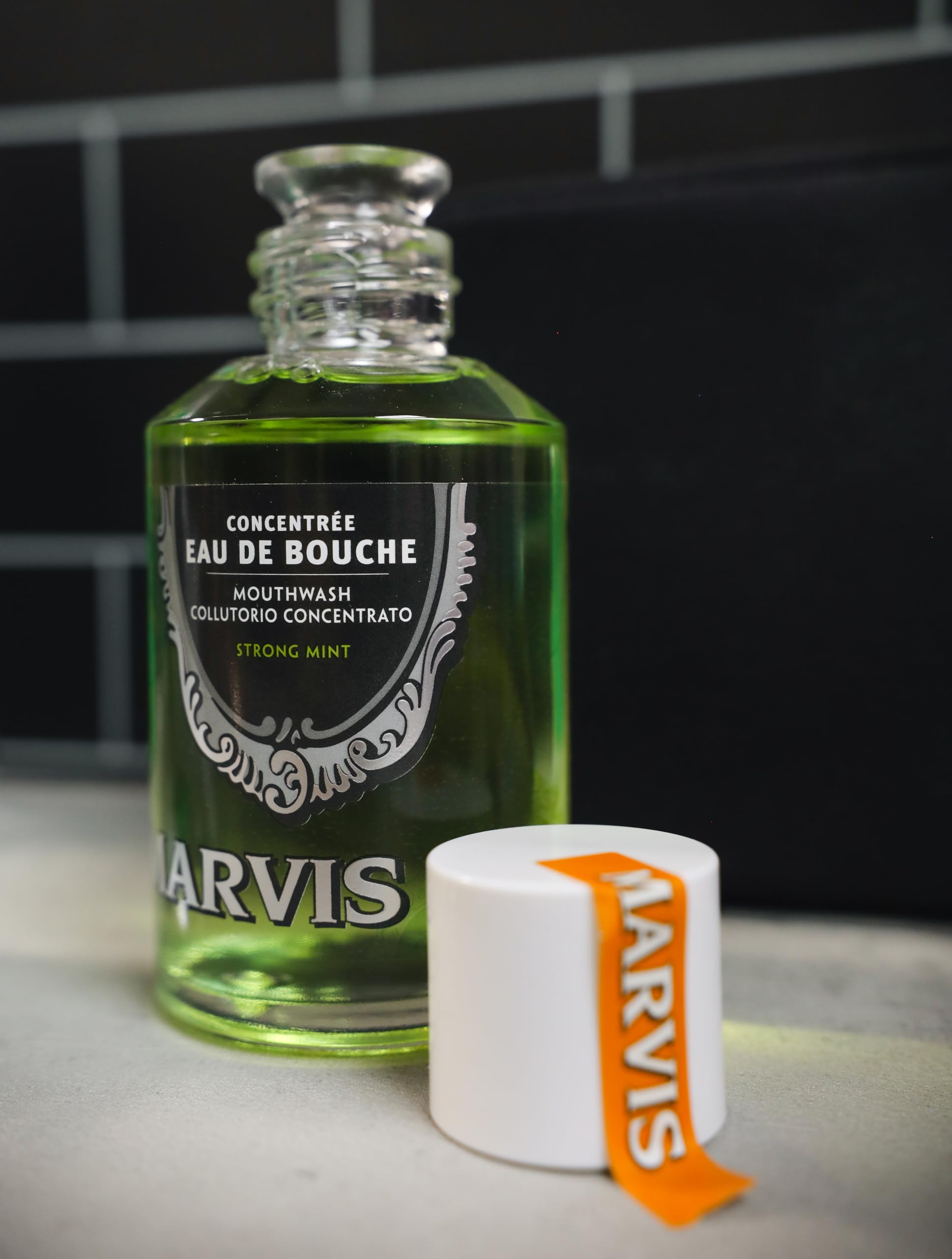 Marvis strong mint mouthwash glass bottle of concentrated green mouthwash with white cap and orange label