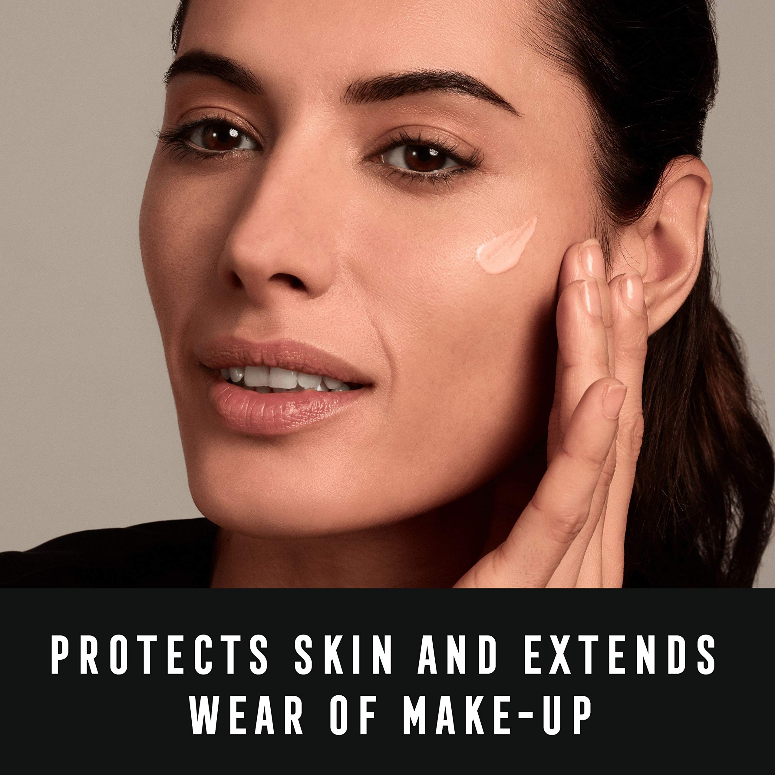 Woman applying Max Factor Miracle Prep primer SPF 30 cream on her cheek for skin protection