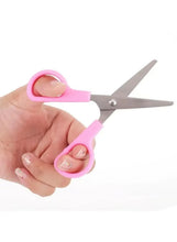 Pink mini safety scissors held in hand, safety cover over blade