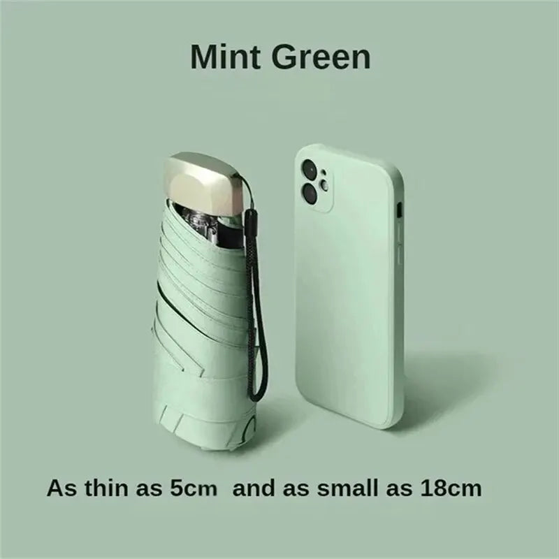 Mumzar mint green mini sun umbrella pocket size next to a smartphone for scale