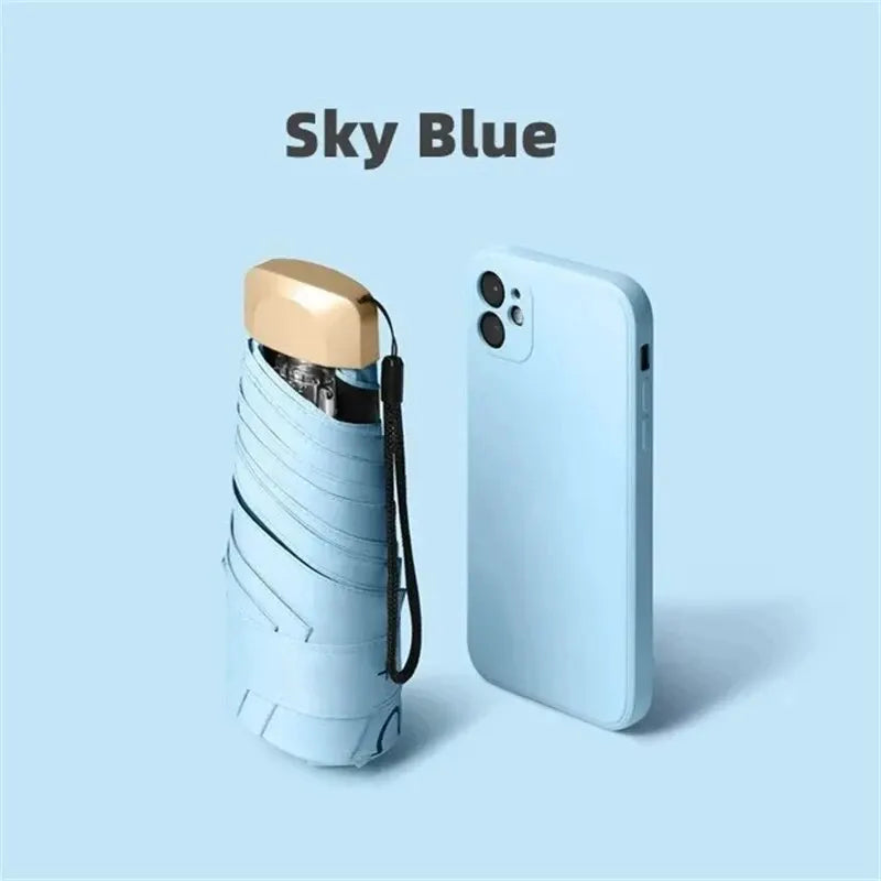 Mumzar mini sun umbrella pocket size in sky blue next to a smartphone for easy portability