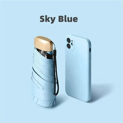 Mumzar mini sun umbrella pocket size in sky blue next to a smartphone for easy portability