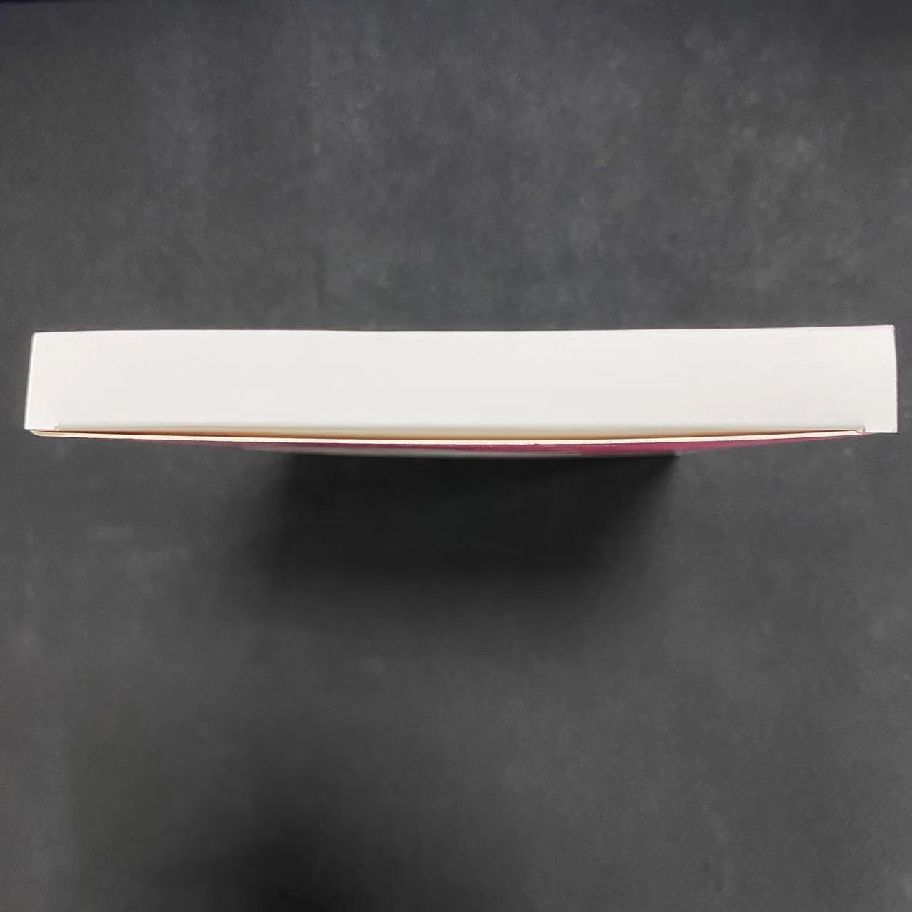Top view of MOMMED HCG midstream pregnancy test white box on black background showing sealed retail packaging