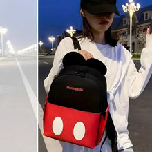 Baby backpack with black top and red front, mouse-ear hood worn on a shoulder strap