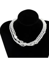 Triple-row pearl choker with oval clasp and small dangling heart charm