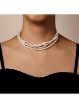Multi-layer pearl choker necklace worn on neck, three bead rows with front bow charm