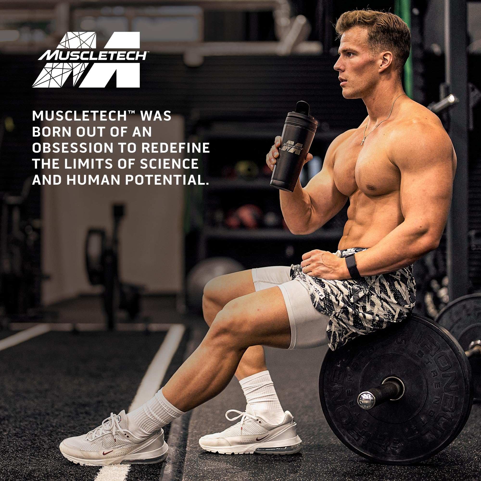 Muscletech multivitamin ad showing muscular man seated on barbell holding shaker in gym glutamine powder for muscle recovery