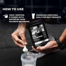 Glutamine supplement tub in black and silver, shown in hands with scoop.