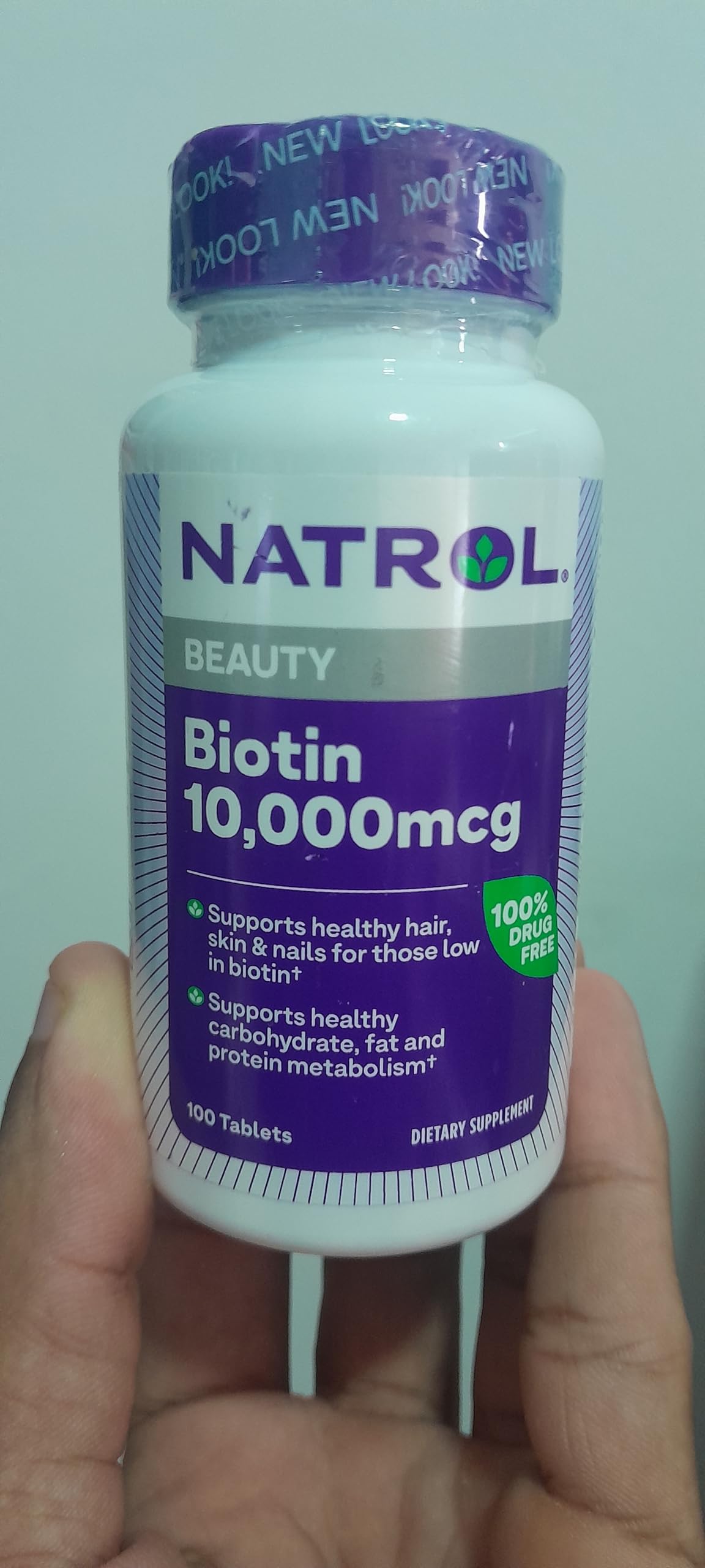 Natrol Biotin 10000 mcg tablets in a bottle, promoting healthy hair, skin, and nails