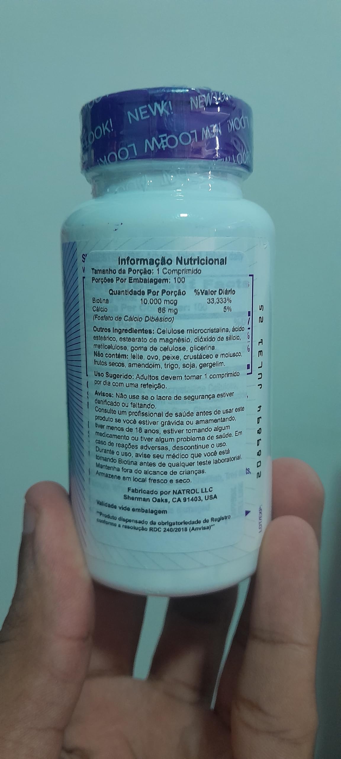 Natrol Biotin 10000 mcg tablets in a white bottle with a blue cap for hair, skin, and nail support