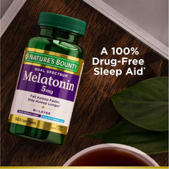 Natures Bounty Melatonin 5 mg bottle on wood table beside tea and leaf highlighting melatonin sleep supplement UAE