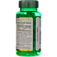 Green bottle of Nature's Bounty magnesium tablets showing supplement facts label and tablets