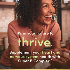 Smiling woman leaning on kitchen counter in ad for Natures Bounty super B complex with folic acid and vitamin C.
