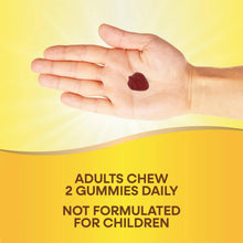 Hand holding two dark red strawberry gummies