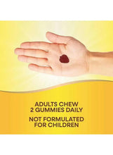 Two strawberry gummies in open palm, adults chew label