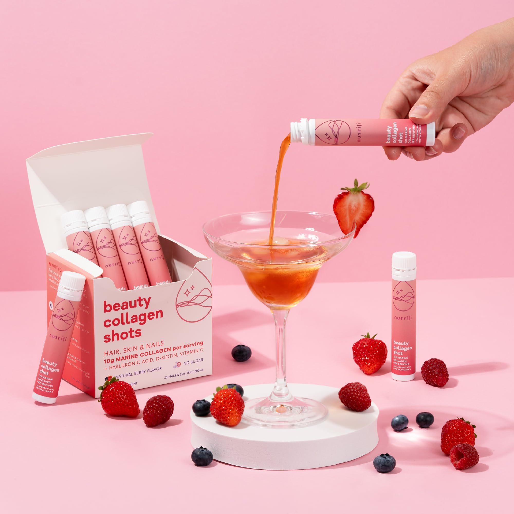 Nutrili beauty collagen shots box and vial poured into cocktail glass with berries marine collagen shots for hair skin and nails