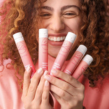 Beauty collagen shots pink vials held by a smiling woman