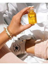 Bonding oil bottle held in a hand with golden oil visible inside