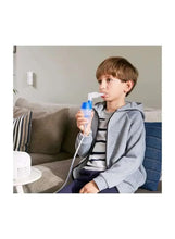 Child using compressor nebulizer with mask and blue cup, connected tubing.