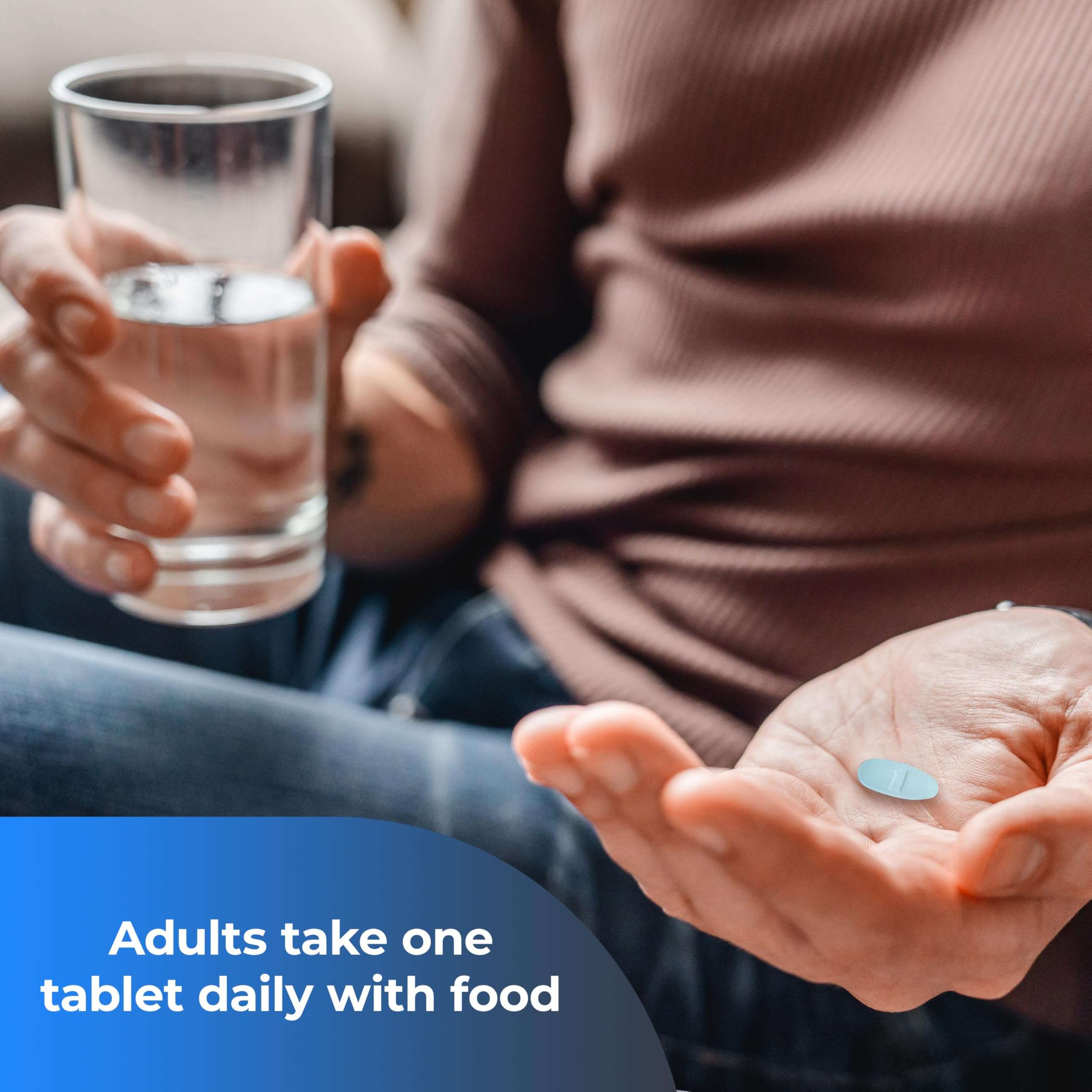 Man holding a daily tablet and glass of water with dosing text for ONE A DAY multivitamin for men over 50