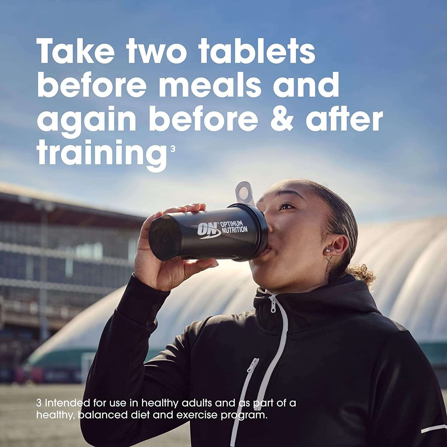 Athlete drinking from Optimum Nutrition shaker bottle outdoors with dosing instructions text Optimum Nutrition Amino 2222 tablets