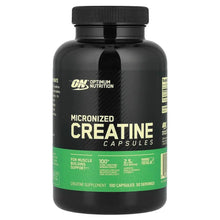 Creatine supplement capsules bottle with black label, green text, and flip-top lid.