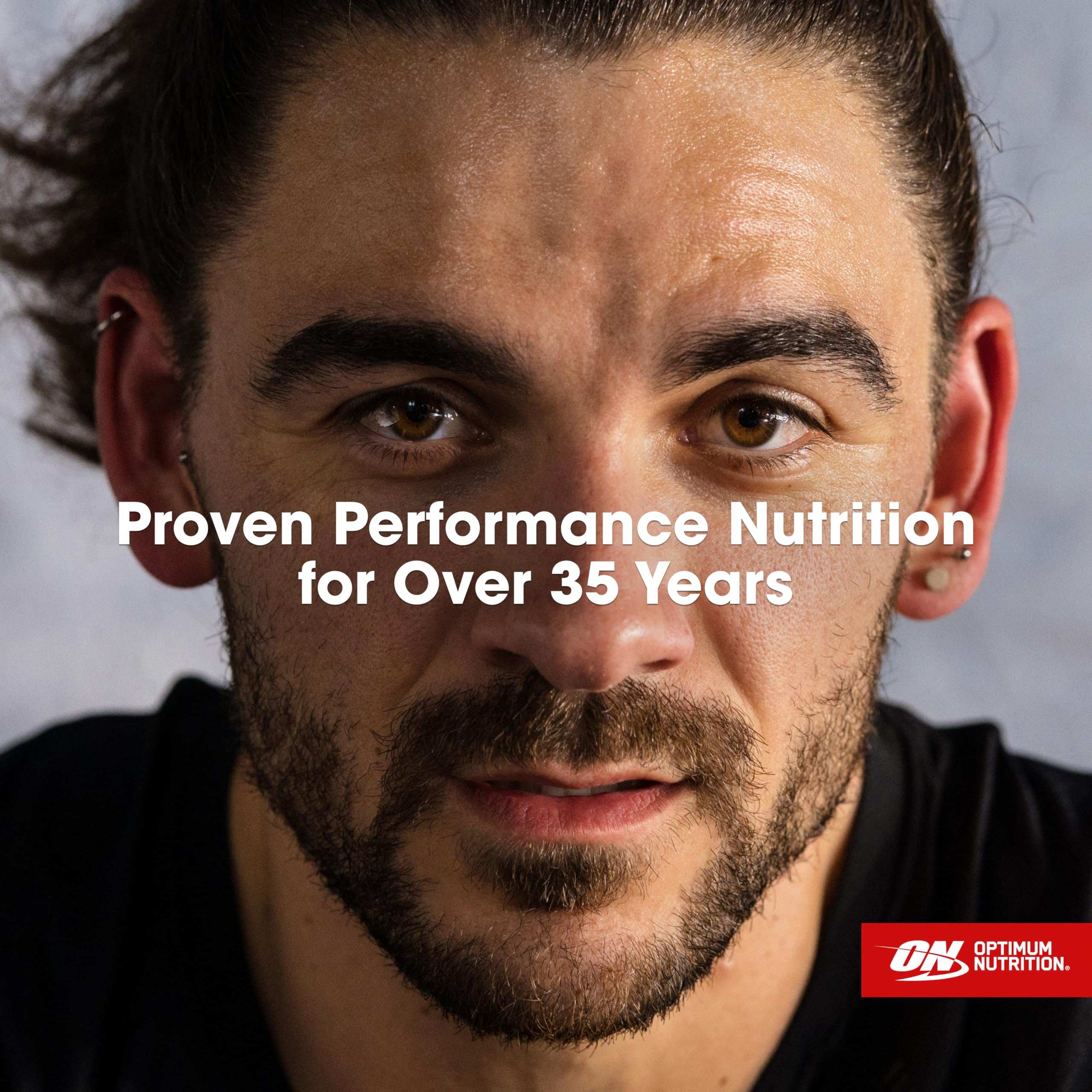 Close up sweaty male athlete face with Optimum Nutrition logo and overlay text promoting whey protein powder UAE