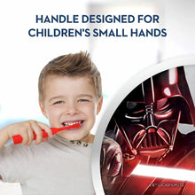 Child holding a red kids electric toothbrush with white bristles