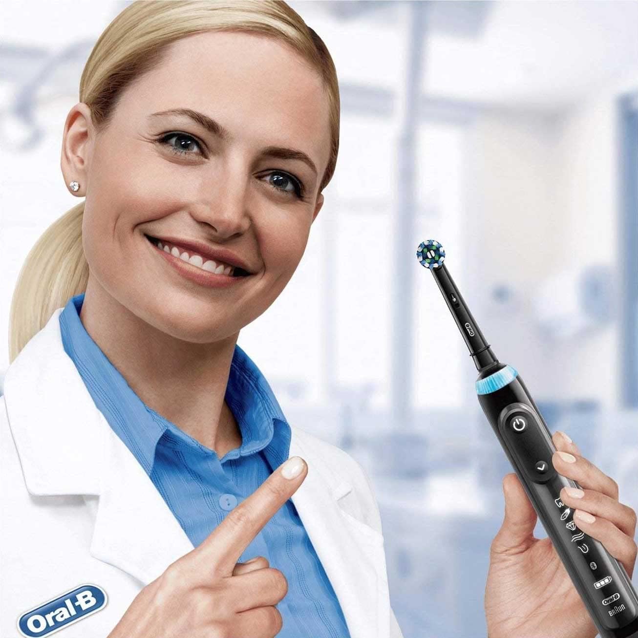 Dentist holding electric toothbrush with round brush head highlighting Oral-B Crossaction replacement heads for deep clean
