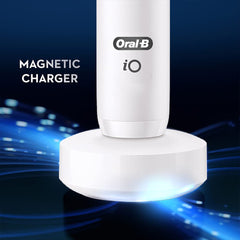 Oral-B iO7 electric toothbrush UAE white handle on magnetic charger with glowing LED base close up