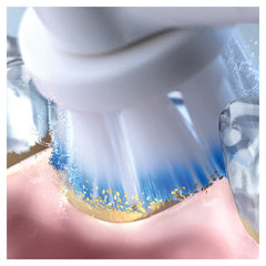 Close up of Oral-B sensitive clean toothbrush heads removing plaque from gum line with blue bristles